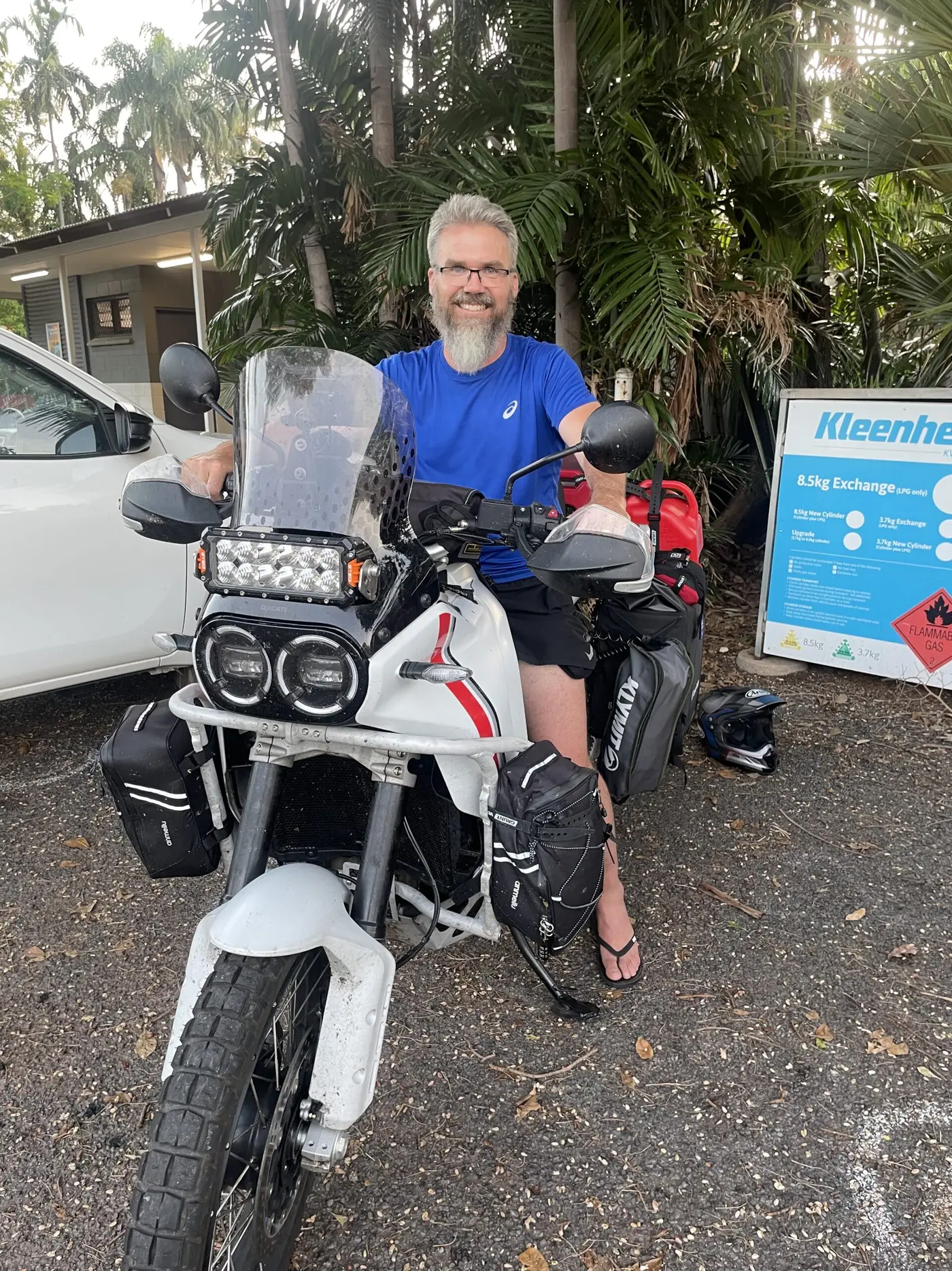 The traveller seated on his fully loaded adventure motorbike, ready to ride.