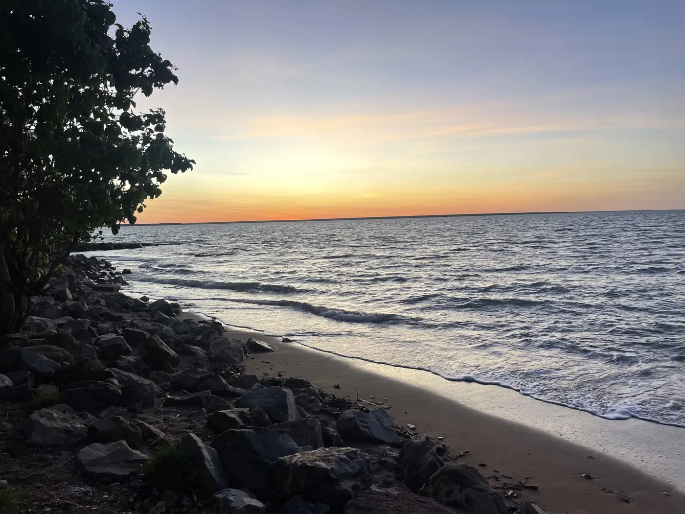 A glowing orange sunset over the water at Darwin.