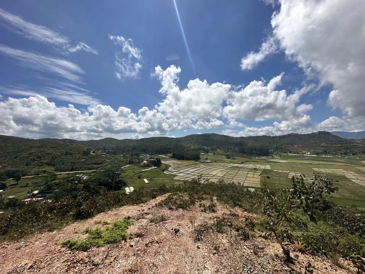 A wide view over green Timor-Leste valleys from a hilltop.