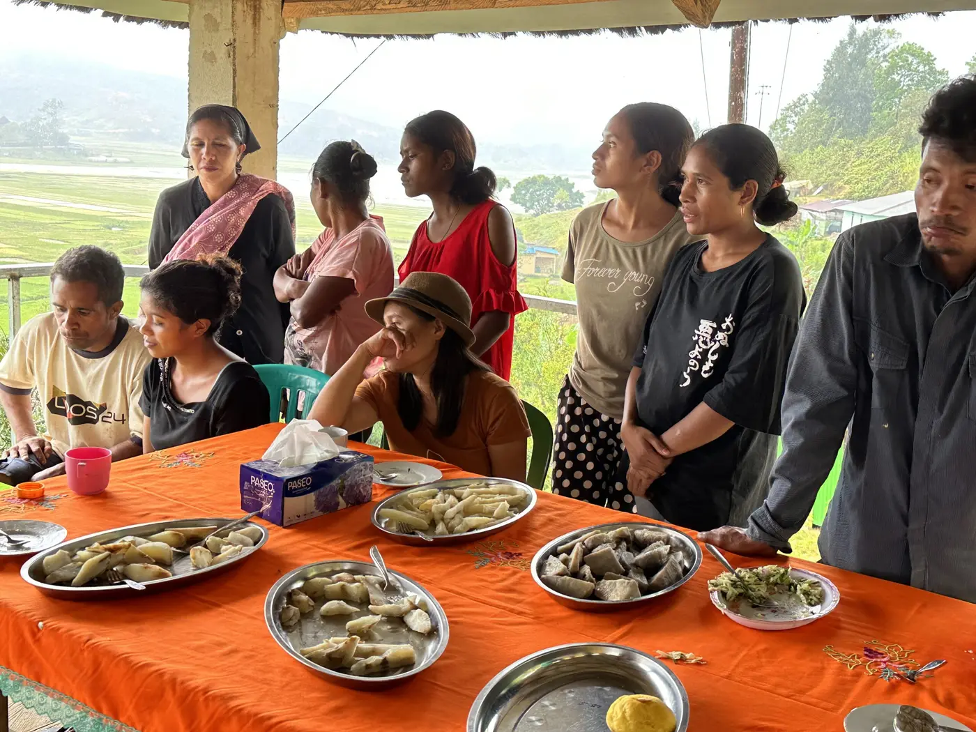Morning tea shared with Timorese villagers around a table by the rice fields.