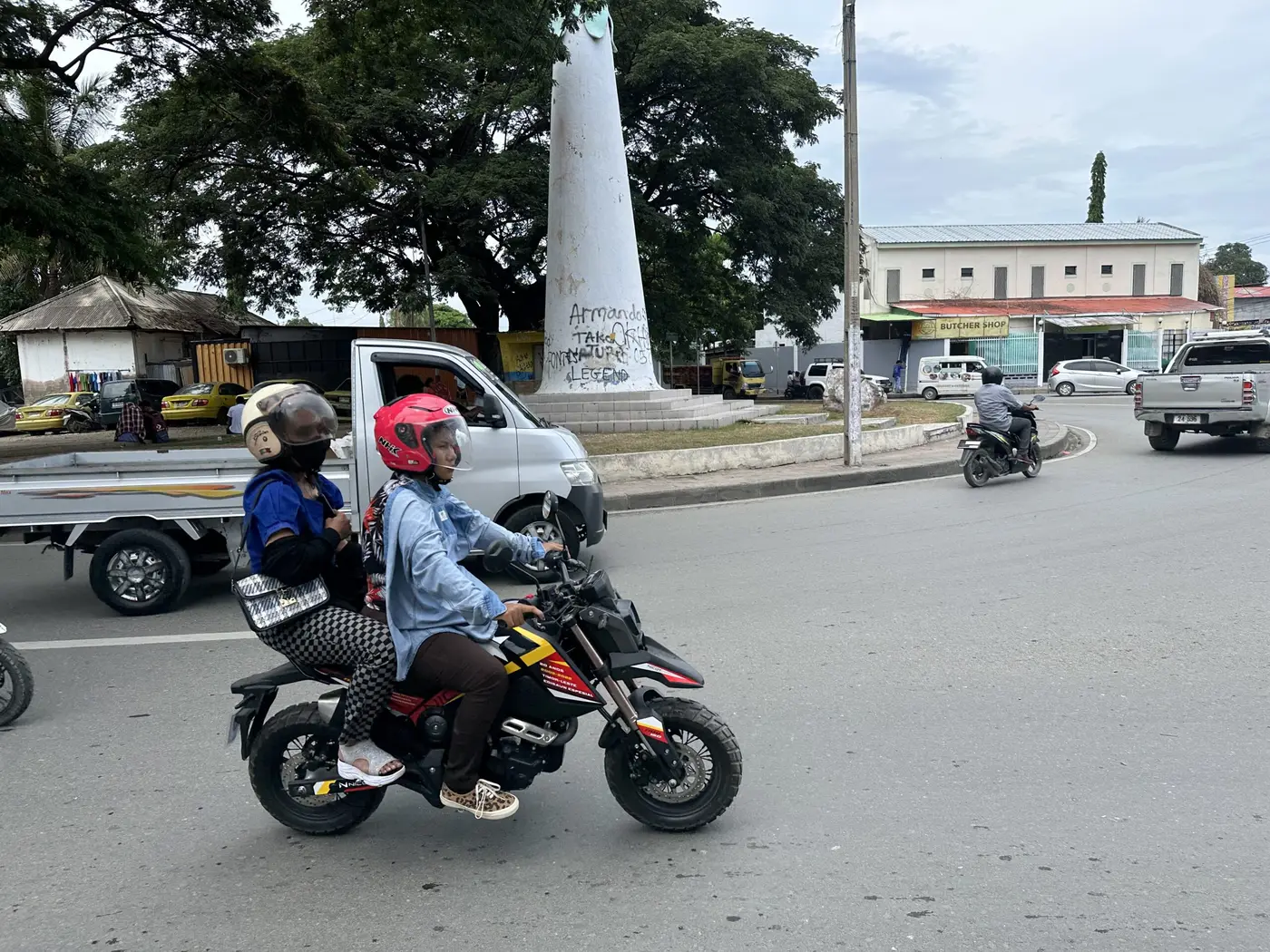 Motorbikes threading through a busy Dili roundabout.