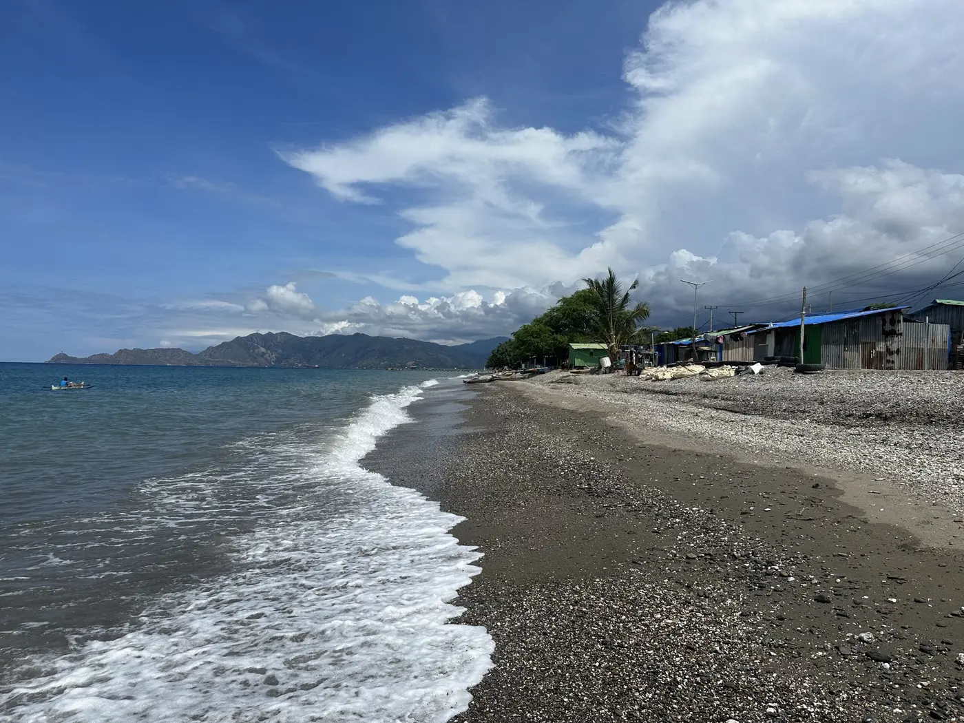 A quiet walk along a black-sand Timor-Leste beach.