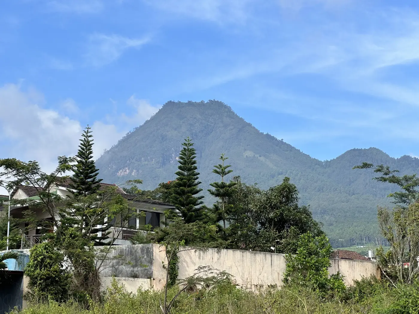 A volcano rising behind a green Indonesian village.
