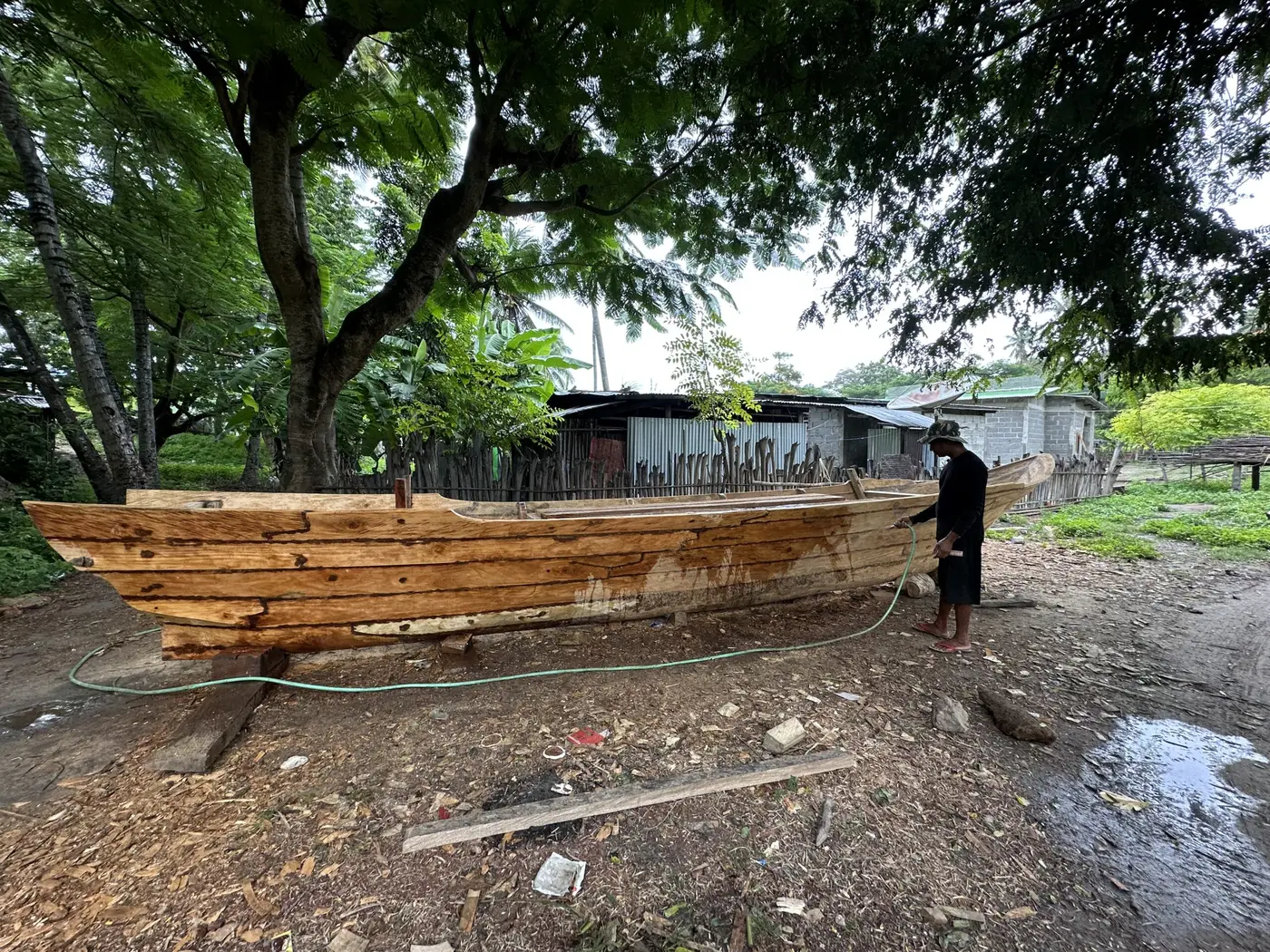 A newly hand-built wooden boat resting on the beach.