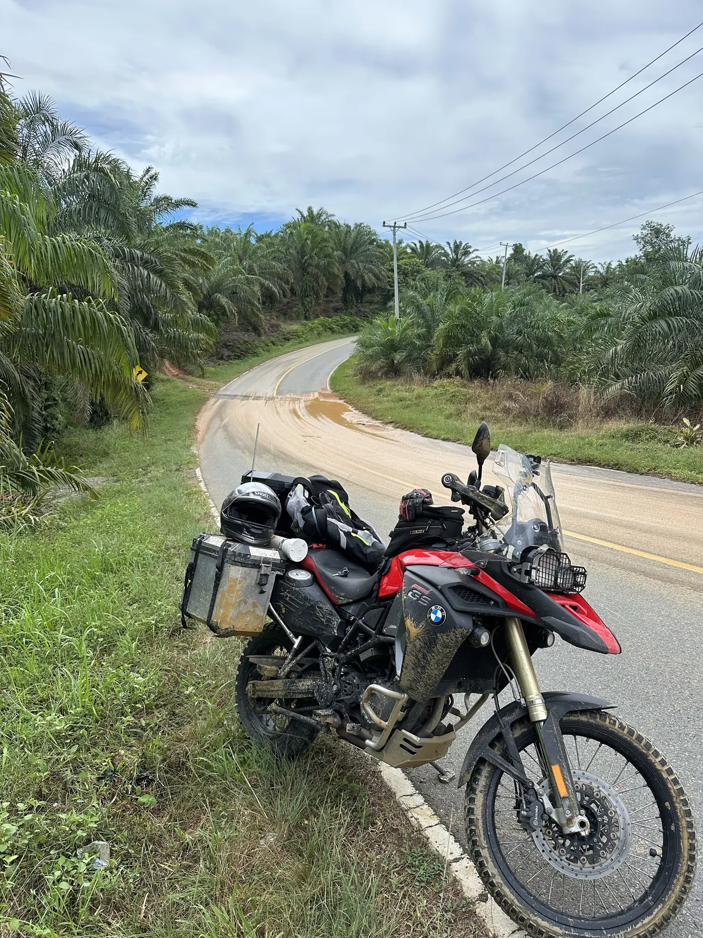 The motorbike down on its side on a slick, muddy corner.